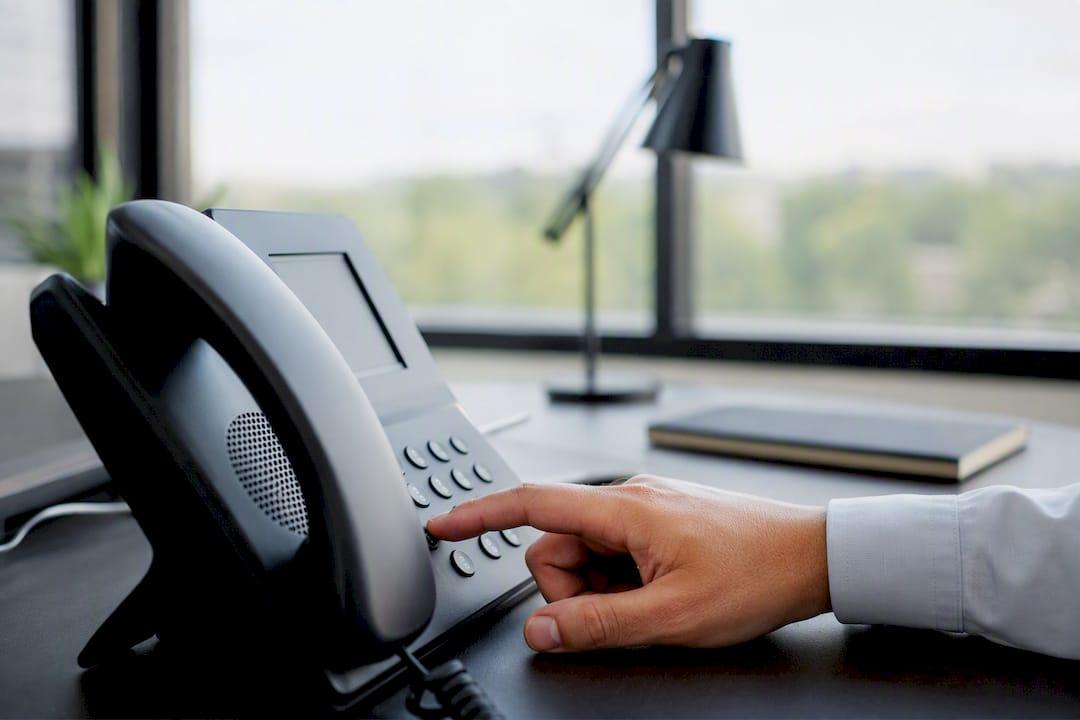 Hand die knoppen van een telefoontoestel bedient